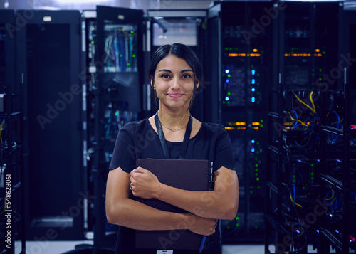 Portrait of smiling female technician in server room photo