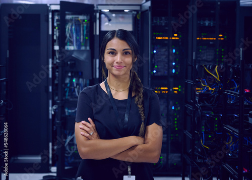 Portrait of smiling female technician in server room photo