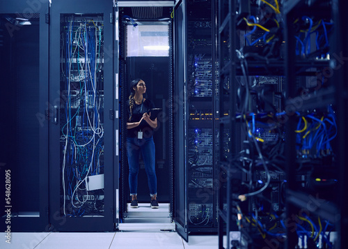 Female technician working in server room