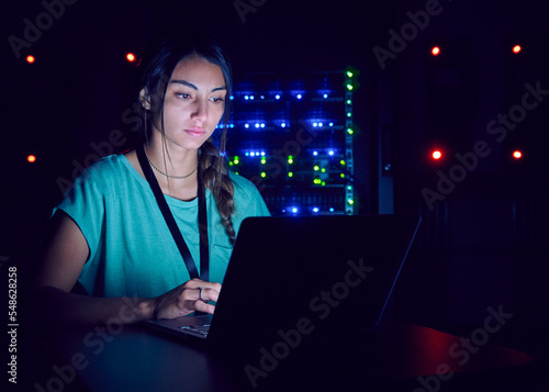 Technician using laptop in server room photo