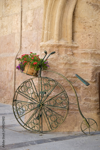 Spain, Cordoba, Penny farthing bicycle planter in front of old stone building