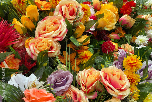 Many multicolored artificial flowers on the counter in the store
