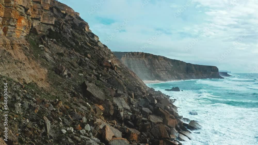 Drone is rising over the rocky Atlantic ocean coastline, Portugal, in summer sunny day. Beautiful aerial view natural landscape with ocean rocky shore. Scenic tourist travel destination. No people. Drone is rising over the rocky Atlantic ocean coastline, Portugal, in summer sunny day. Beautiful aerial view natural landscape with ocean rocky shore. Scenic tourist travel destination. No people.