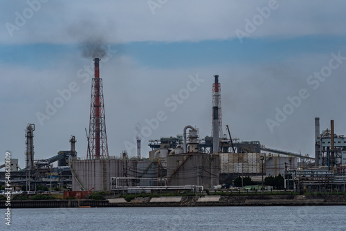 Smoke is coming out of factories chimney near the sea in Kitakyushu city Japan.