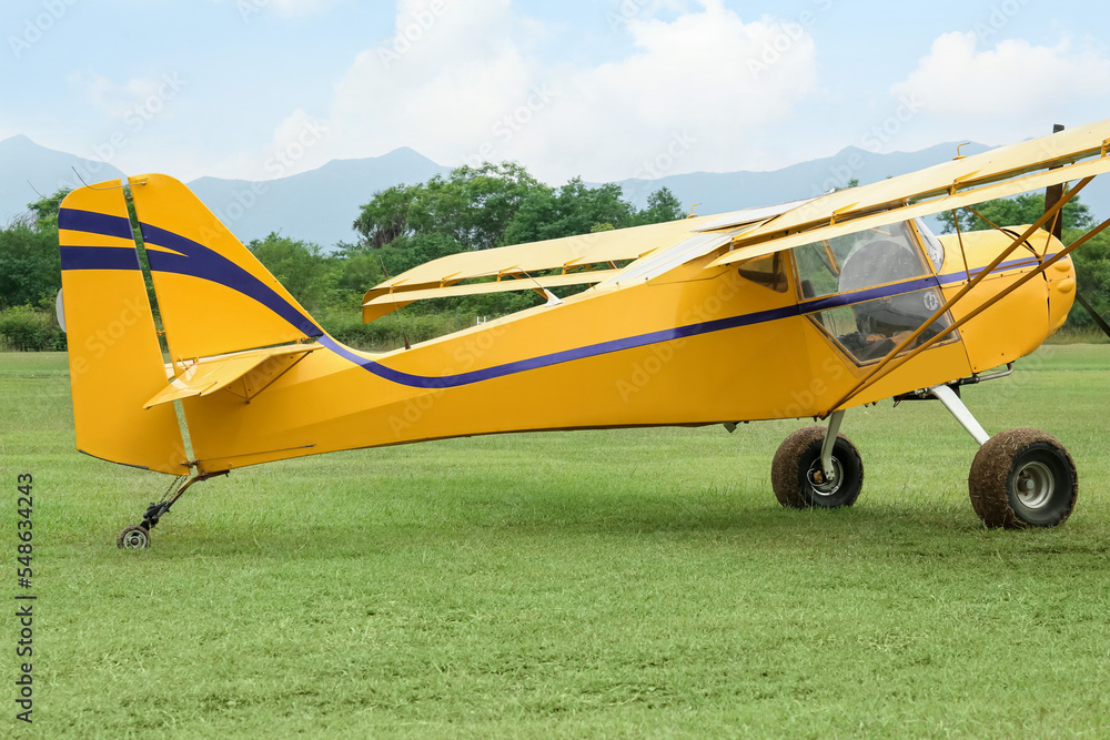View of beautiful ultralight airplane in field on autumn day View of beautiful ultralight airplane in field on autumn day