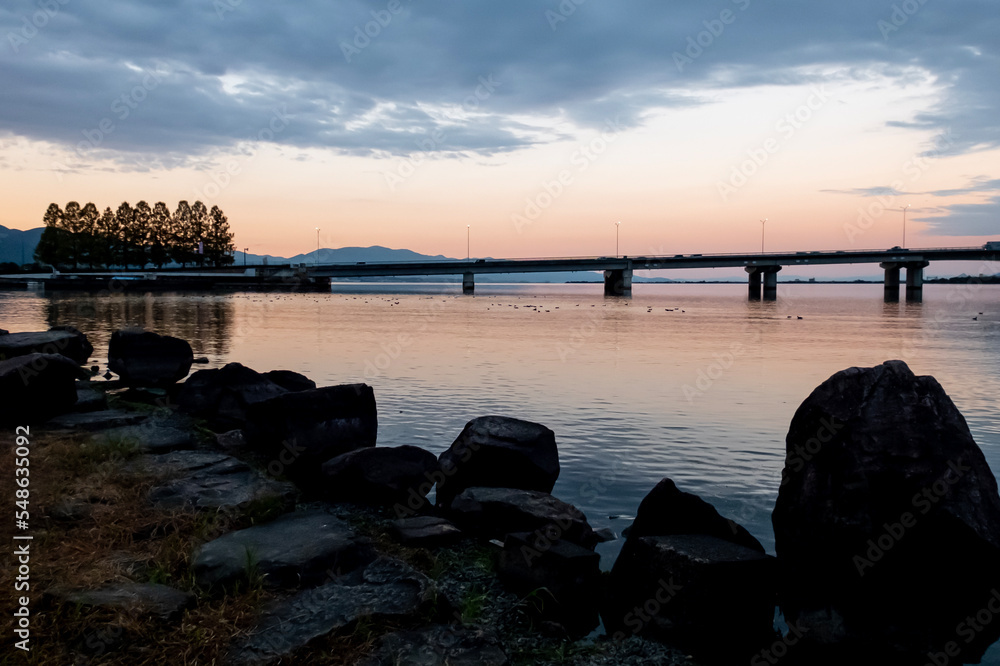Fototapeta premium 琵琶湖のオレンジの夕焼けを背景にした近江大橋