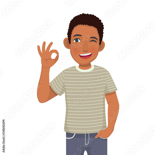 Happy young African man winking showing okay hand sign gestures
