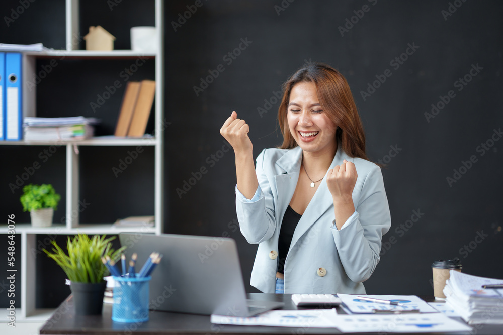Beautiful Asian businesswoman with laptop in the office. Happy and the work came out successfully and satisfactorily achieved the goal. Beautiful Asian businesswoman with laptop in the office. Happy and the work came out successfully and satisfactorily achieved the goal.