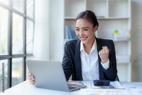 Фотография Beautiful Asian businesswoman with laptop in the office