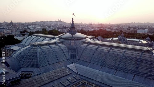 Beautiful aerial shot of architectural wonder, a castle of glass, the Grand Palais, Paris from above at sunrise with Montmartre at horizon.  photo