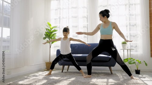 Portrait of young asian mother  daughter prepare for stretching post in yoga meditation. Mom and little girl toddler yoga exercise on yoga mat at home. Together lifestyle, Mother's Day concept