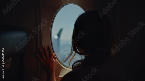 Girl on plane puts hand up to airplane window