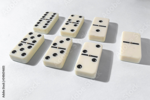 Domino pieces with white background  copy space and various agulos  concept of table games