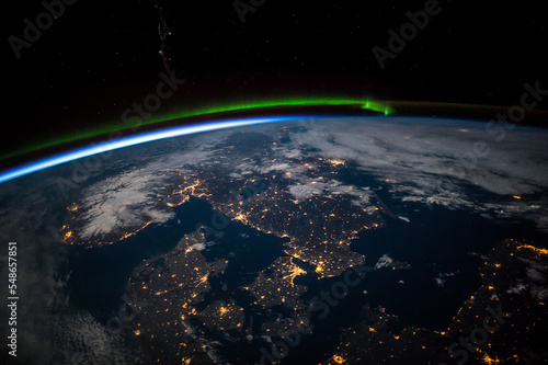 Aerial view from above Earth showing Scandinavia at night. Green aurora above the northern Baltic Sea. Image courtesy of the Earth Science and Remote Sensing Unit, NASA Johnson Space Center.