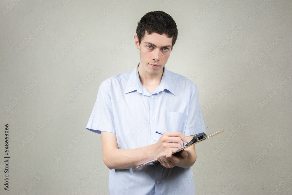 Young man with clipboard on light background Young man with clipboard on light background