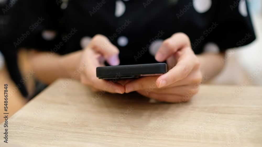 Close-up of woman's hand scrolling her smartphone with blur background, 4K. Close-up of woman's hand scrolling her smartphone with blur background, 4K.