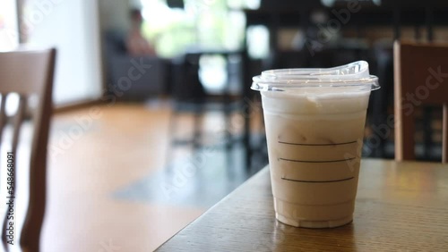 Close-up of a plastic cup of iced coffee with blur background.