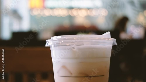Close-up of a plastic cup of iced coffee with blur background.