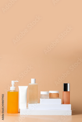 Different skincare product set. Fcial cleanser, toner, essence, serum, cream on white podium beige background. Beauty salon and cosmetic shop