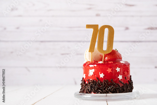 The number Seventy on a red birthday cake on a light background