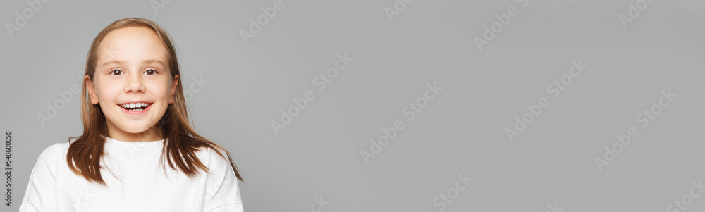 Cute happy playful kid schoolgirl posing on white banner background, closeup studio portrait. Childhood concept Cute happy playful kid schoolgirl posing on white banner background, closeup studio portrait. Childhood concept
