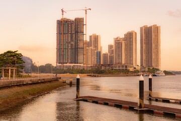 Acrylglasbilder Stadt am Wasser Danga Bay Skyline bei Sonnenuntergang  © Syafiq Mansor/Wirestock Creators