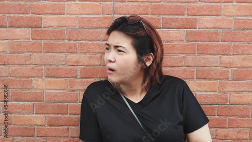 A young Asian woman is feeling a bit bored with the outdoor scene.