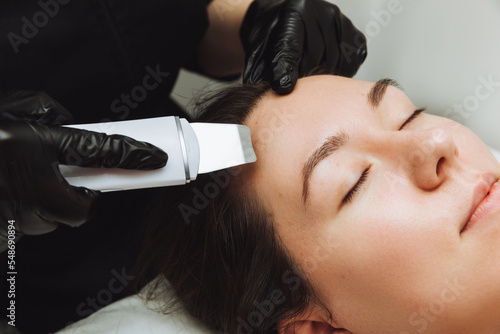 Skin care. Close-up Of A Beautiful Woman Receiving An Ultrasound Facial Peeling. Ultrasonic skin cleaning procedure. Cosmetic procedures. Cosmetology.