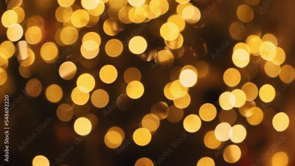 Beautiful festive background with golden bokeh from a garland on a Christmas tree. Yellow and orange lights in the dark. Beautiful festive background with golden bokeh from a garland on a Christmas tree. Yellow and orange lights in the dark.