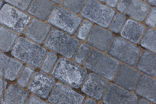 Paving tile texture on the bottom of the street. stone floor background. Concrete sidewalk tiles. Modern textured sidewalk tile square and rectangular flooring in the works. tile and sand. 