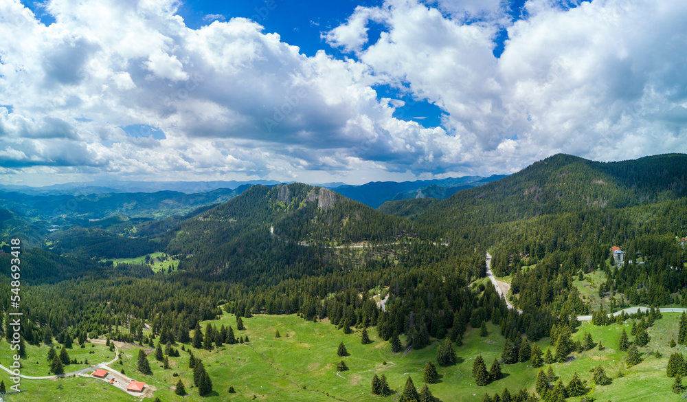 Valley of Balkan mountains with fog, sunny clouds and forests. Village Pamporovo. Panorama, top view