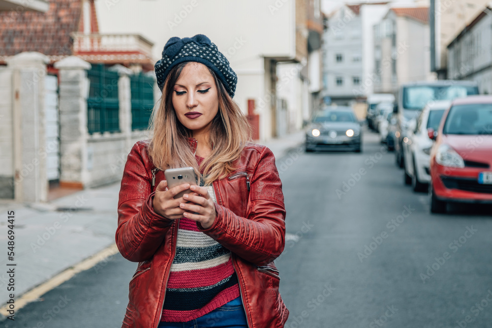 Fototapeta premium young woman using smart phone in the street