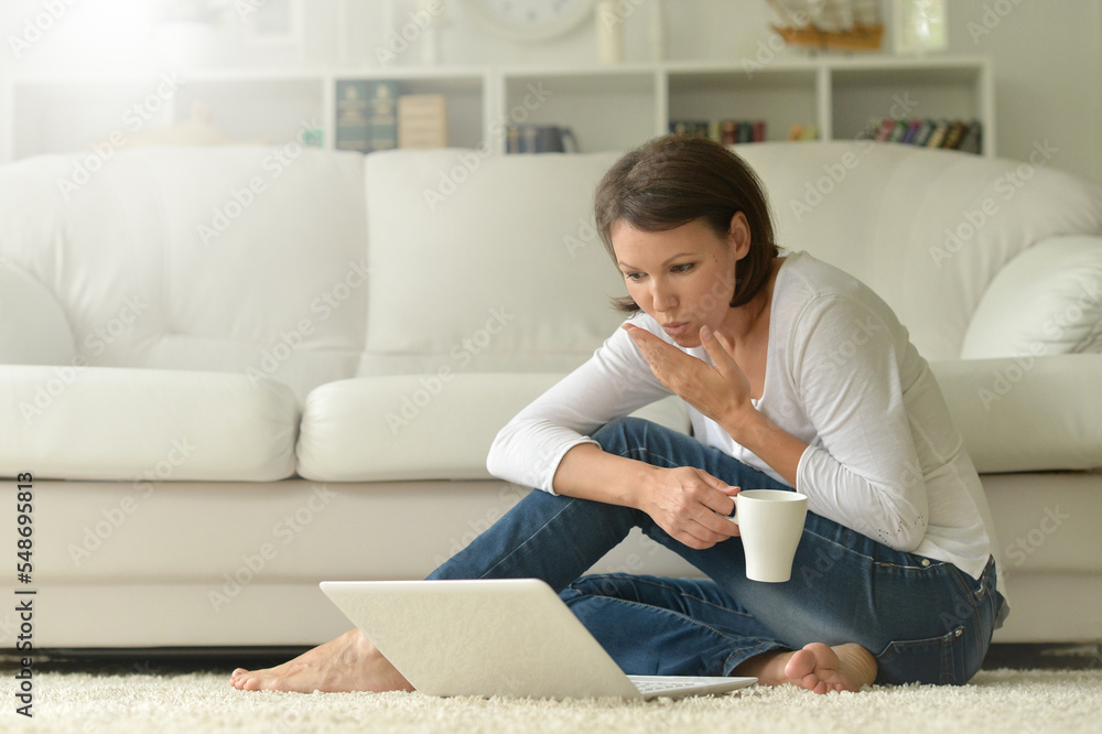 Portrait of a beautiful woman with a laptop on the floor Portrait of a beautiful woman with a laptop on the floor