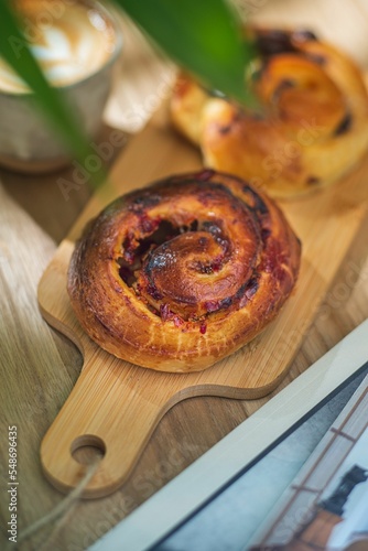 Vertical top view of two raisin chocolate rolls placed on a wooden board