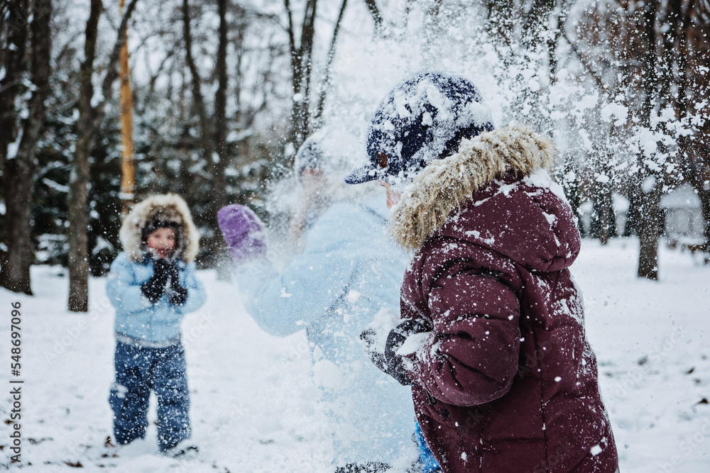 Happy Family, friends, mother and kids having fun outdoors in winter snowy nature background