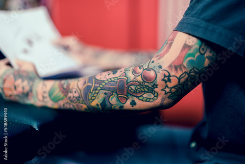 Tattoo artist checking patterns for customers in Studio lowlight.