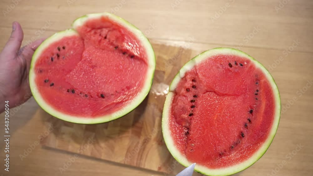 Aesthetics top view of cut ripe red watermelon on wooden board, chef cut fresh fruit with kitchen knife, juicy watermelon prepared for eating. Watermelon fruits rich of vitamins good for human body Aesthetics top view of cut ripe red watermelon on wooden board, chef cut fresh fruit with kitchen knife, juicy watermelon prepared for eating. Watermelon fruits rich of vitamins good for human body