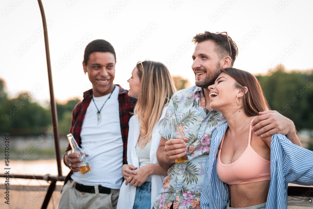Fototapeta premium Group of multietnical friends enjoying on river boat party, drinking beer having a great time