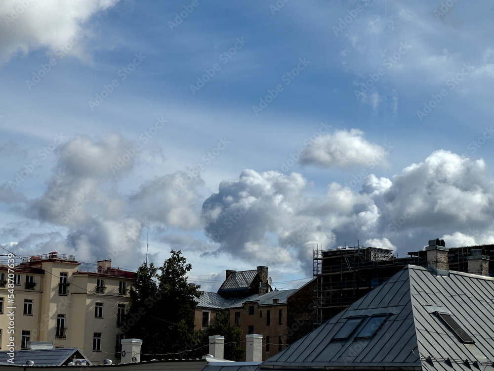 View on roofs and cloudy sky in a town, selective focus View on roofs and cloudy sky in a town, selective focus