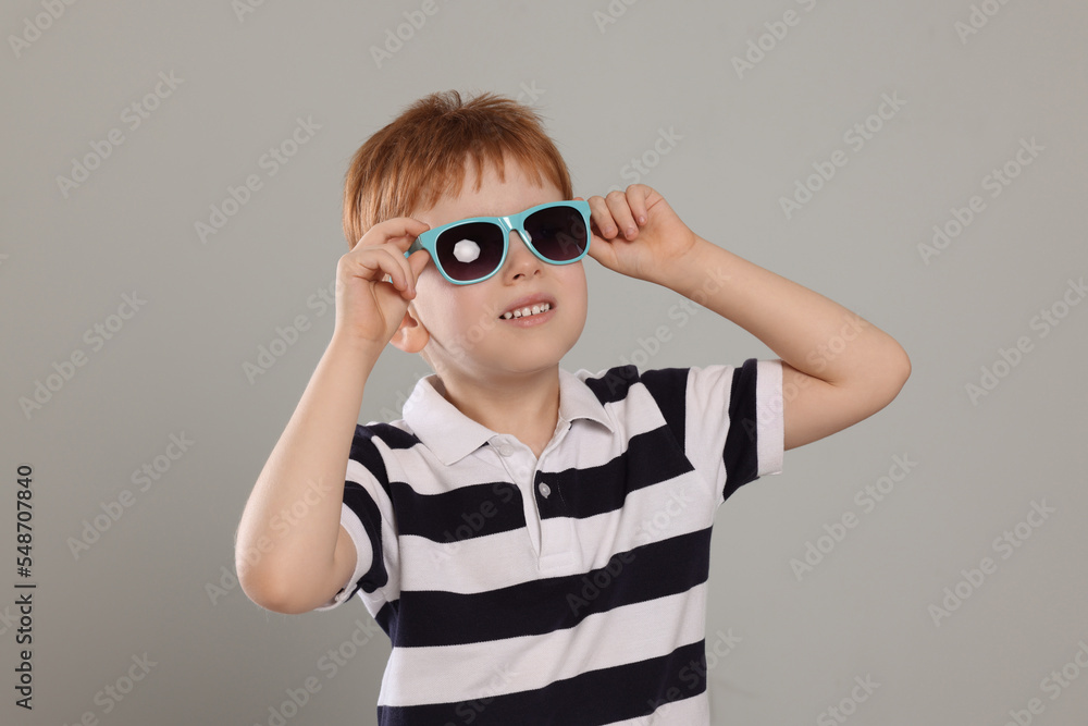 Cute little boy with sunglasses on light grey background Cute little boy with sunglasses on light grey background