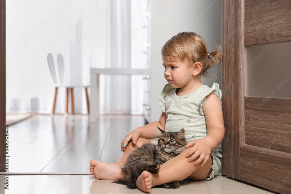 Cute little child with adorable pet on floor at home Cute little child with adorable pet on floor at home