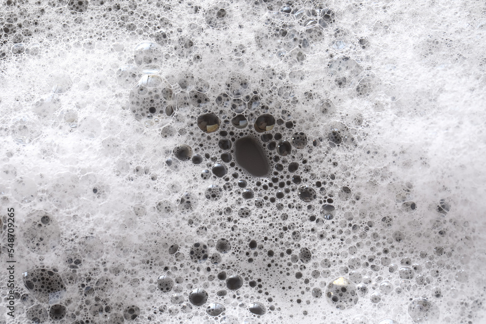 White washing foam on dark gray background, top view White washing foam on dark gray background, top view