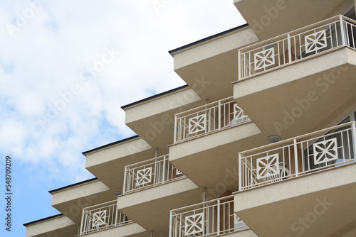 Fototapeta Exterior of beautiful building with balconies against blue sky, low angle view