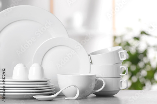 Set of clean dishware on light table photo