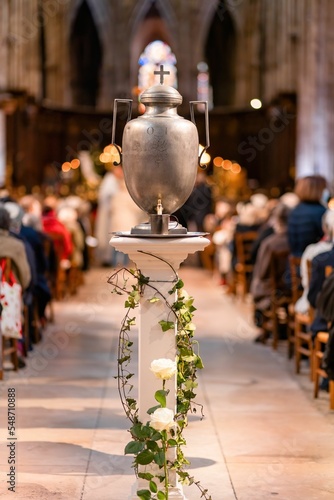 Vertical shot of a metallic vase filled with oil prepared to be blessed by the b Fototapeta