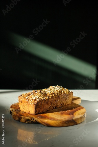 Vertical shot of sweet bread placed on a wooden board on a black background
