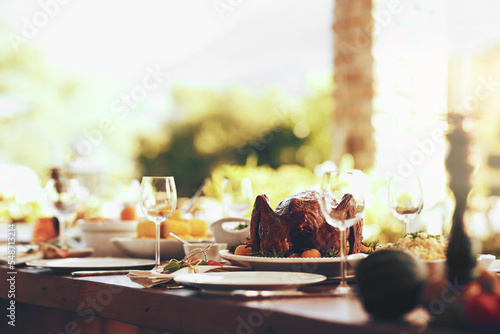 Food  table and traditional celebration on a patio with no people for thanksgiving  party and a fun gathering setup for family at home. Turkey  chicken and dining table ready for family lunch outdoor