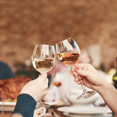 Hands, wine glass and toast with wine at party, holiday celebration and couple drinking. Dinner party, celebrate together with food, drink and celebrating Christmas, Thanksgiving or anniversary.