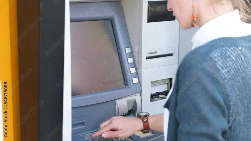 A woman uses an ATM. Close-up A woman uses an ATM. Close-up
