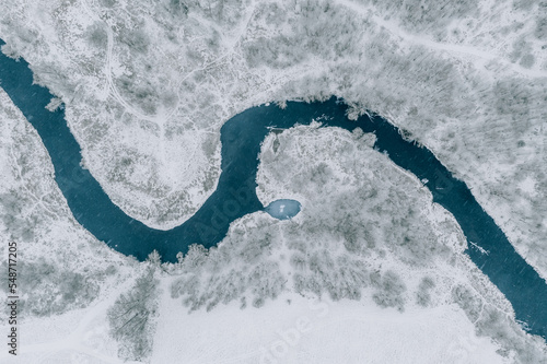 Aerial top view of winding blue river, snow winter landscape photo